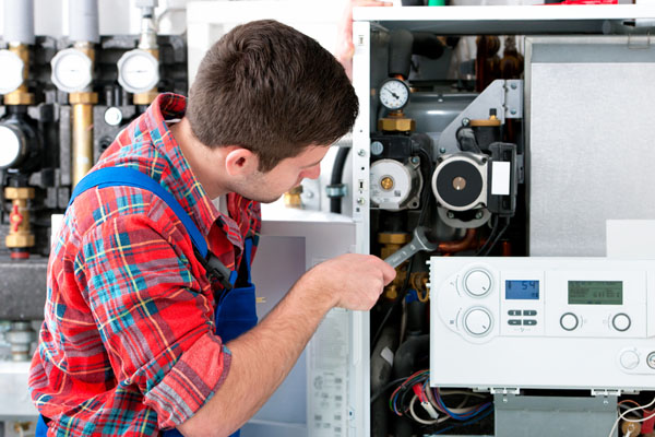 Heating technician repairing boiler controls in Gardena