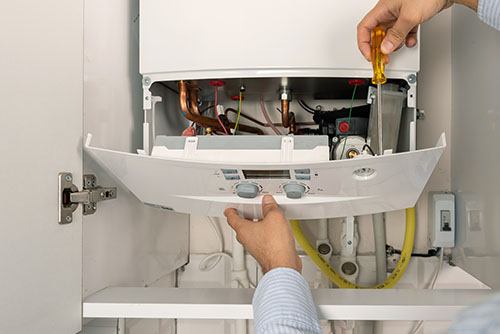 Heating technician repairing a residential boiler in Gardena