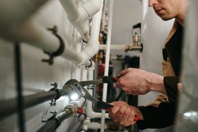 Technician inspecting commercial plumbing pipes in Gardena