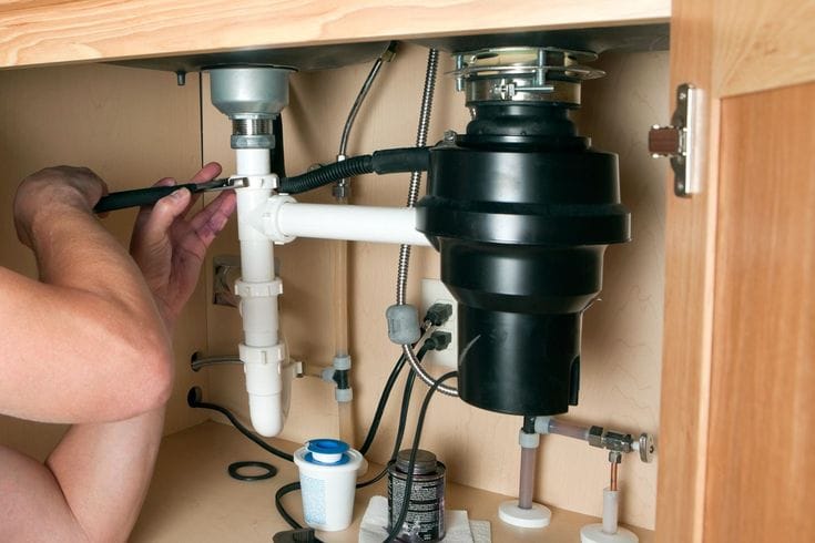 Plumber repairing a garbage disposal in Gardena