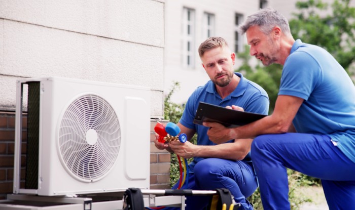 HVAC technicians installing an outdoor air conditioning unit in Gardena