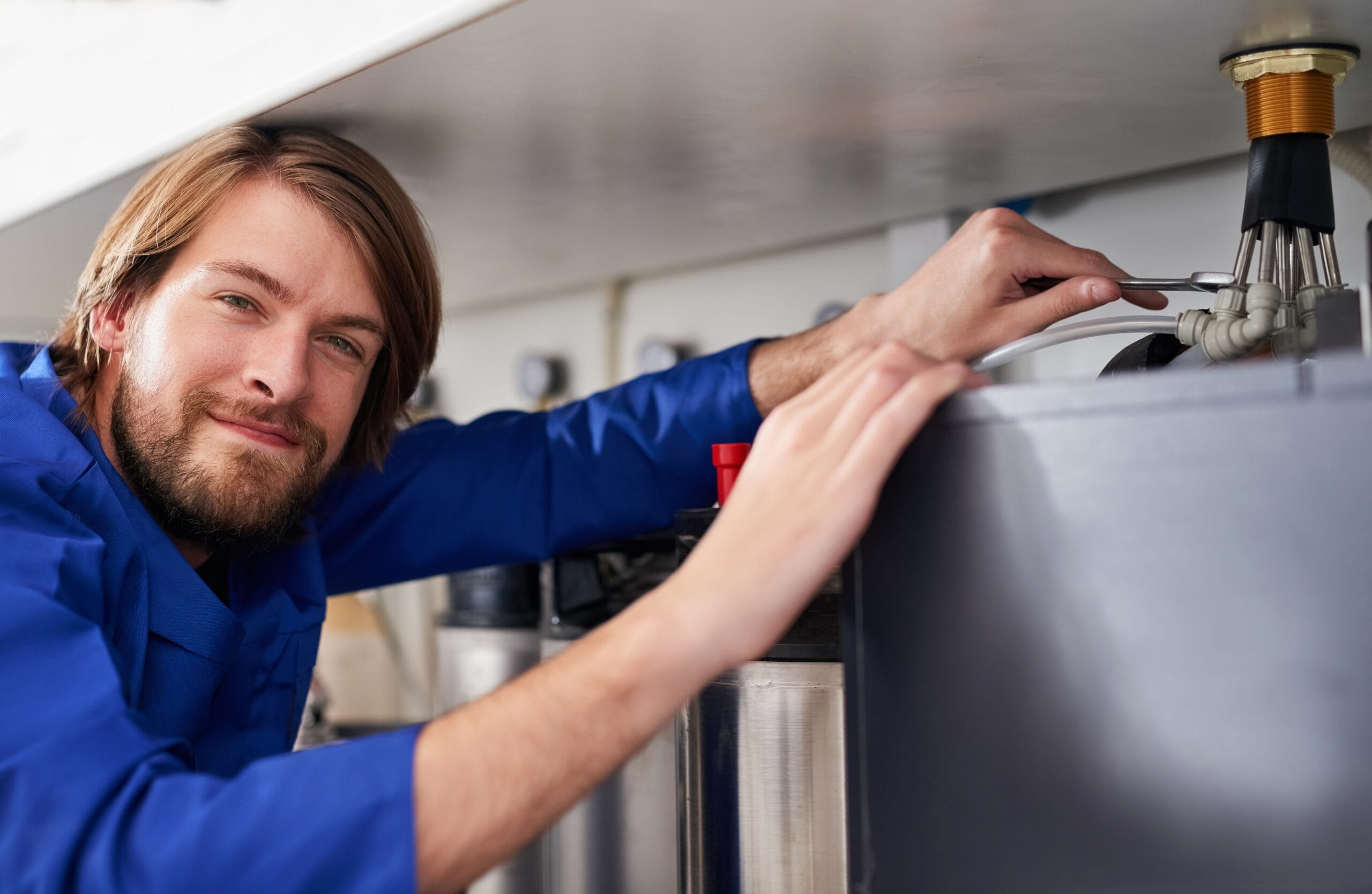 Technician servicing a residential water heater tank in Gardena